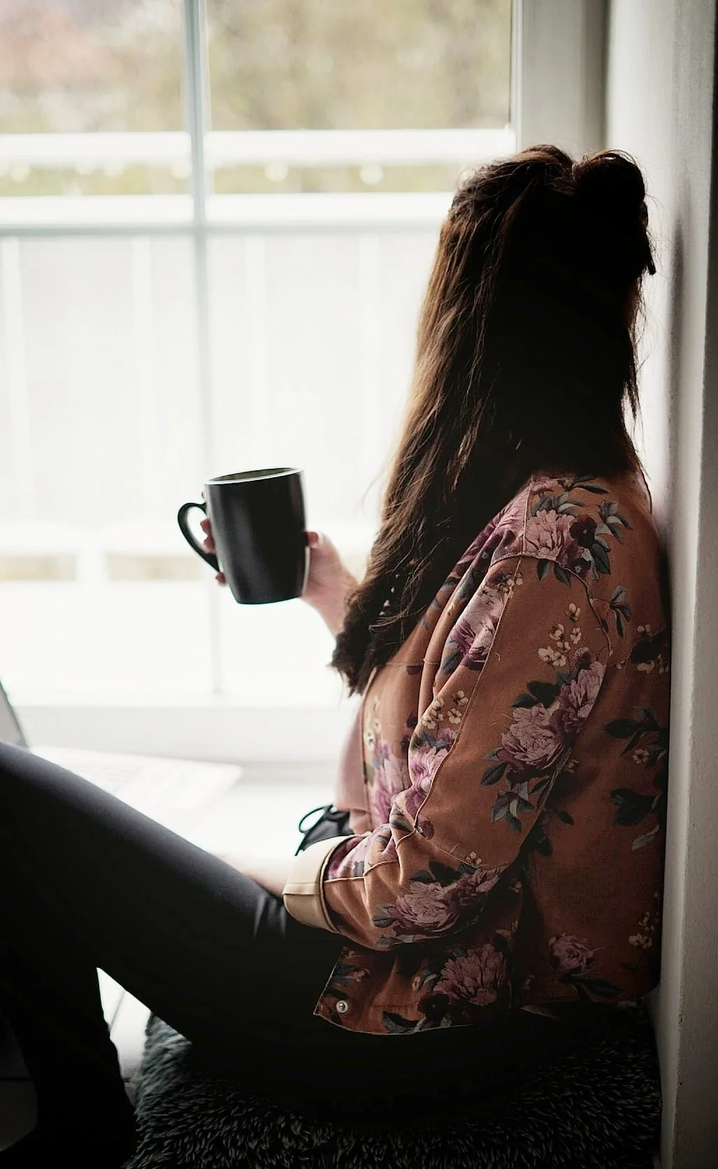 Juliane Mlynar mit einer Tasse Kaffee am Fenster