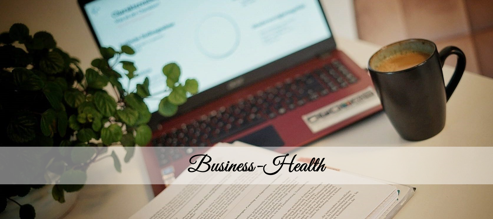 Arbeitsplatz mit Laptop, Kaffeetasse, Pflanze und Dokumenten – darüber liegt der Schriftzug „Business–Health“.
